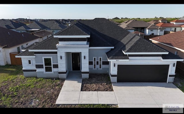 view of front facade with a garage, a residential view, and roof with shingles