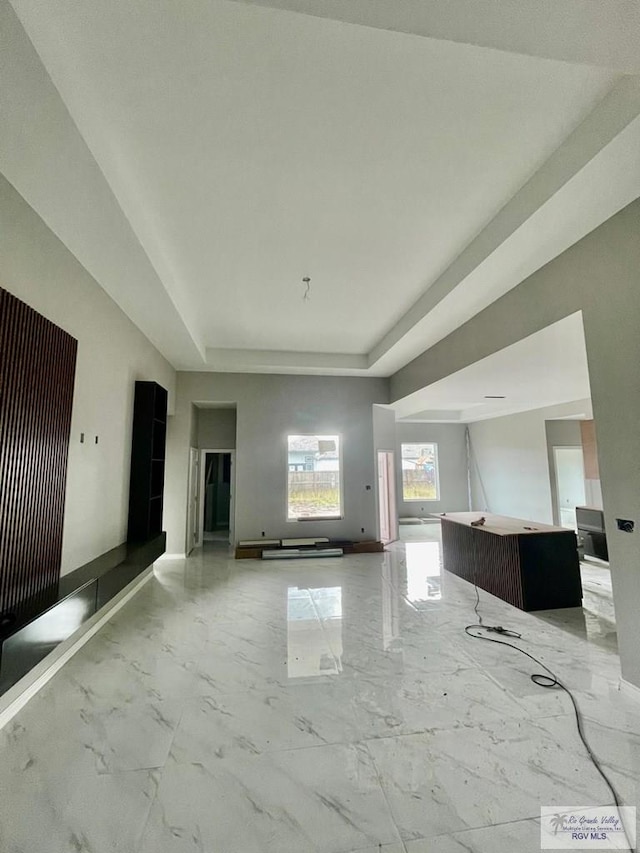 unfurnished living room with a tray ceiling