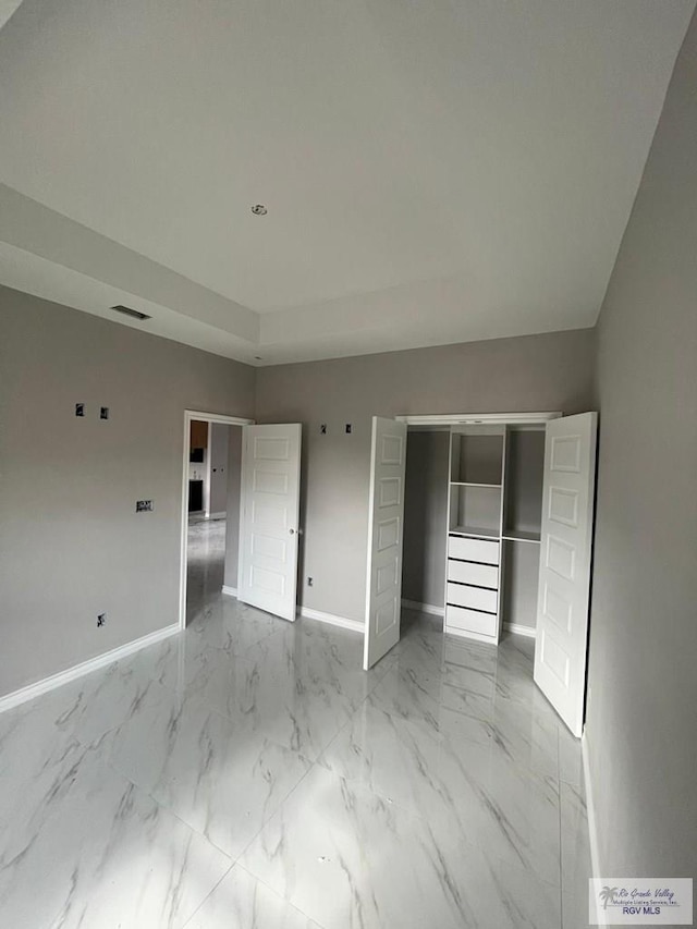 unfurnished bedroom featuring a closet, visible vents, baseboards, and marble finish floor