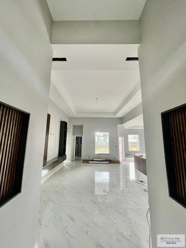 unfurnished living room featuring a tray ceiling