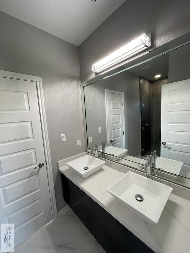 full bathroom with a sink, marble finish floor, and double vanity