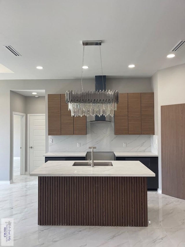 kitchen with modern cabinets, visible vents, marble finish floor, and a sink