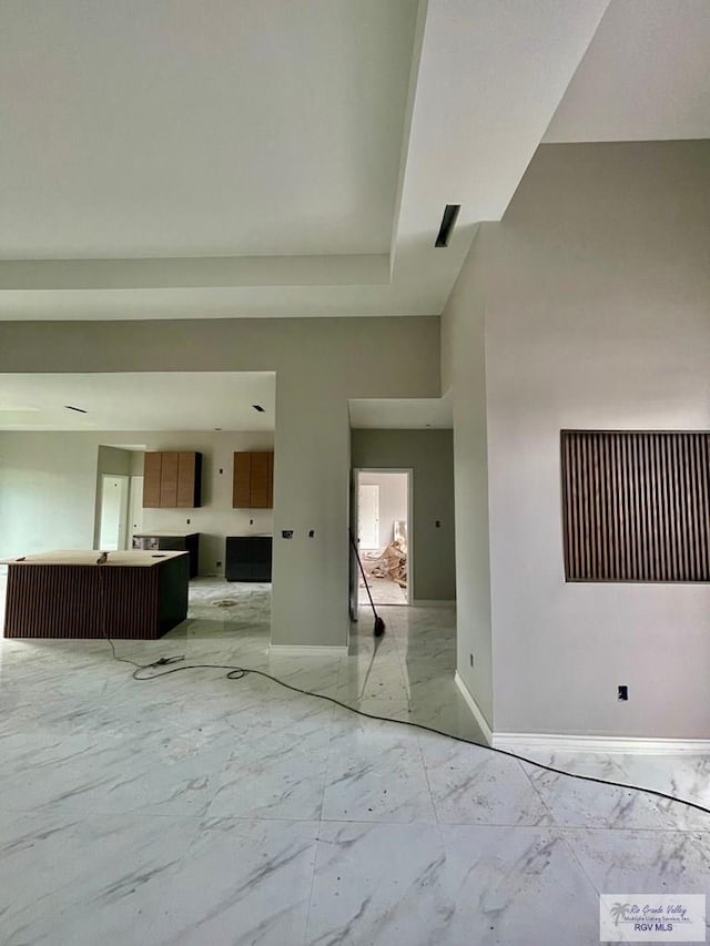 empty room featuring marble finish floor and baseboards