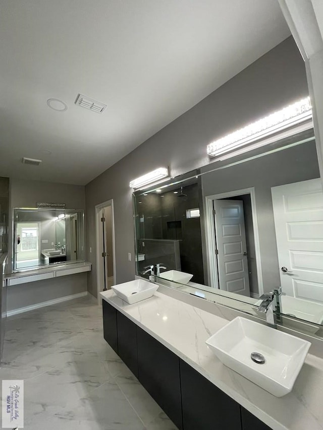 bathroom with visible vents, marble finish floor, a walk in shower, a sink, and double vanity