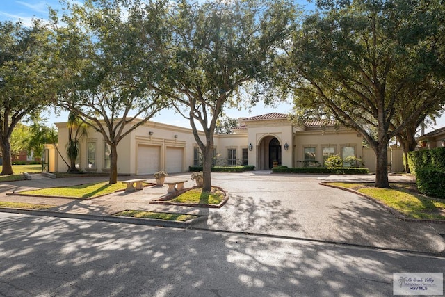 mediterranean / spanish-style home with a garage