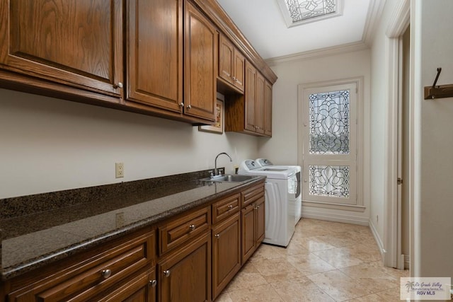 laundry area featuring washer and clothes dryer, cabinets, ornamental molding, and sink