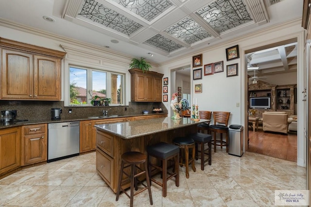 kitchen with a center island, coffered ceiling, crown molding, stainless steel dishwasher, and dark stone countertops