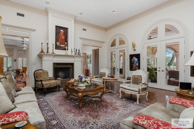 living room with ceiling fan, dark hardwood / wood-style flooring, crown molding, and french doors