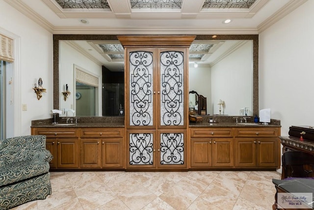 bar featuring dark stone countertops, sink, and ornamental molding