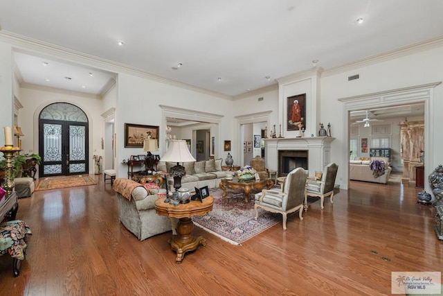 living room featuring ceiling fan, wood-type flooring, crown molding, and french doors