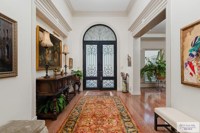 entryway with ornamental molding, light hardwood / wood-style flooring, and french doors