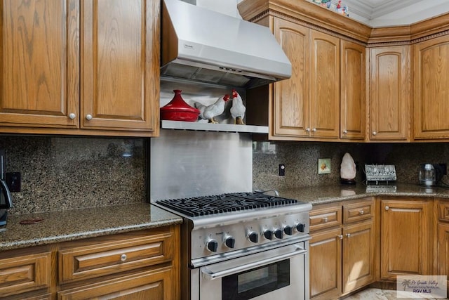 kitchen featuring tasteful backsplash, dark stone counters, extractor fan, high end range, and ornamental molding