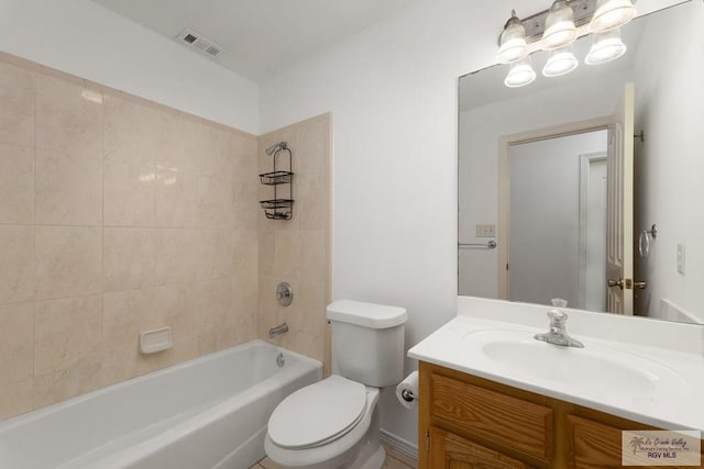 full bathroom featuring tiled shower / bath, vanity, and toilet