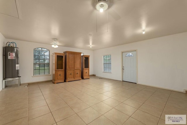 unfurnished living room featuring electric water heater, ceiling fan, and light tile patterned flooring