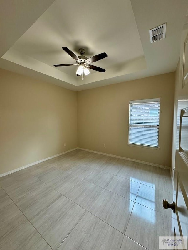 2611 E Eisenhower Ave Unit 50, Alton, TX 78573 - spare room featuring a raised ceiling, light tile patterned floors, ceiling fan, and baseboards