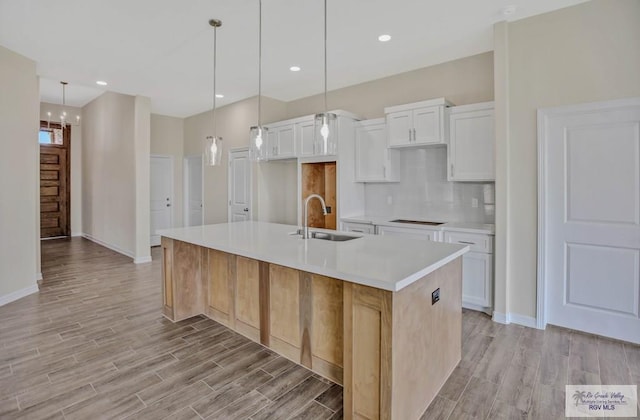 1829 Stirrup Cir, San Benito, TX 78586 - kitchen featuring a sink, light wood finished floors, backsplash, white cabinetry, and recessed lighting