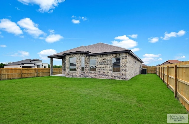 1829 Stirrup Cir, San Benito, TX 78586 - back of property with brick siding, roof with shingles, and central AC unit