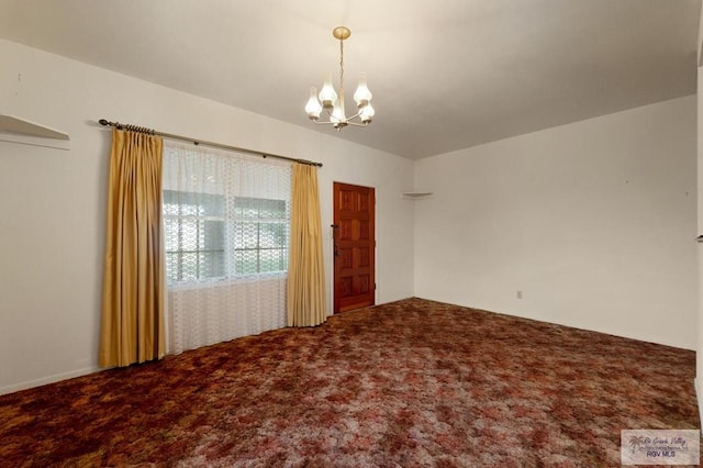 empty room with carpet flooring and a notable chandelier