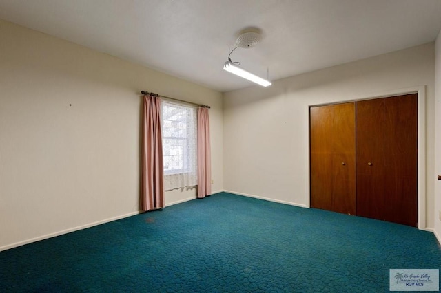 carpeted spare room with baseboards