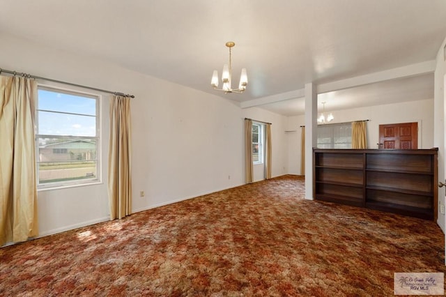 carpeted spare room with a chandelier