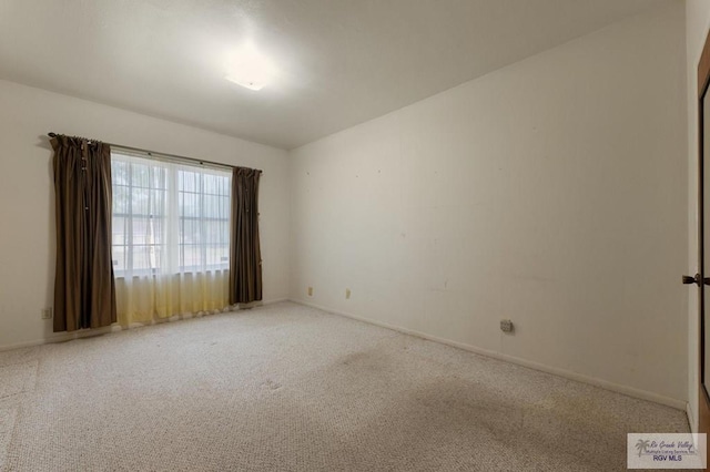 carpeted spare room featuring baseboards