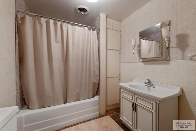 full bathroom with visible vents, vanity, and shower / bath combination with curtain