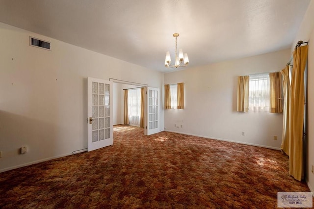 unfurnished room featuring baseboards, visible vents, a notable chandelier, and carpet flooring