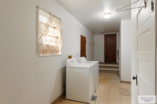laundry area with baseboards, washer and clothes dryer, and laundry area