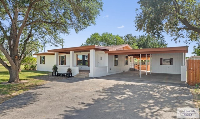 23570 Stuart Place Rd, Harlingen, TX 78552 - rear view of house featuring asphalt driveway, an attached carport, and entry steps