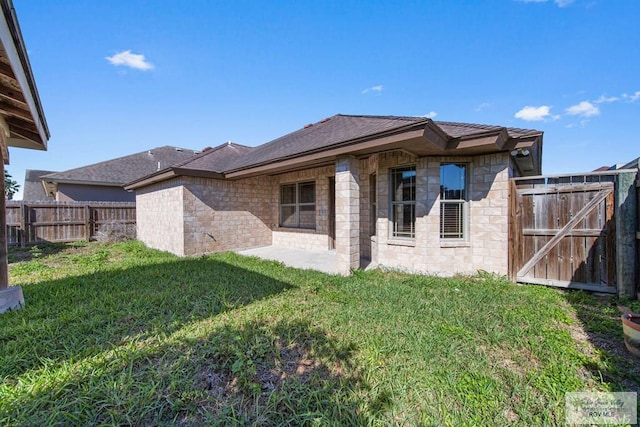 rear view of property with a yard, a patio area, and fence