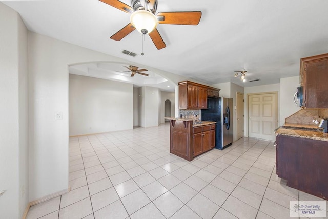 kitchen with arched walkways, visible vents, backsplash, appliances with stainless steel finishes, and open floor plan