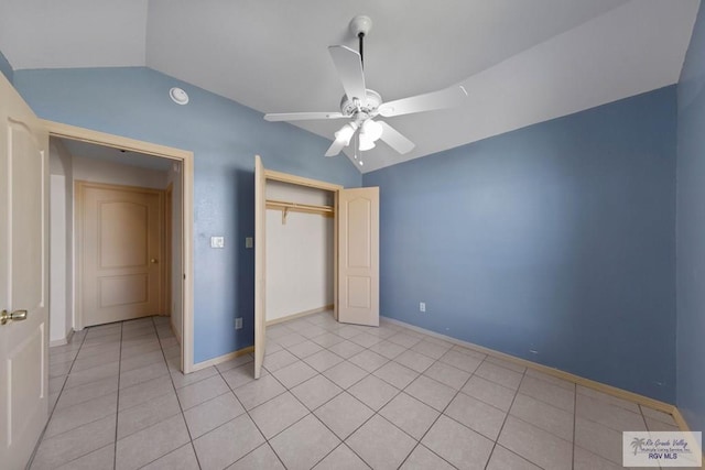 unfurnished bedroom with a closet, a ceiling fan, light tile patterned flooring, vaulted ceiling, and baseboards