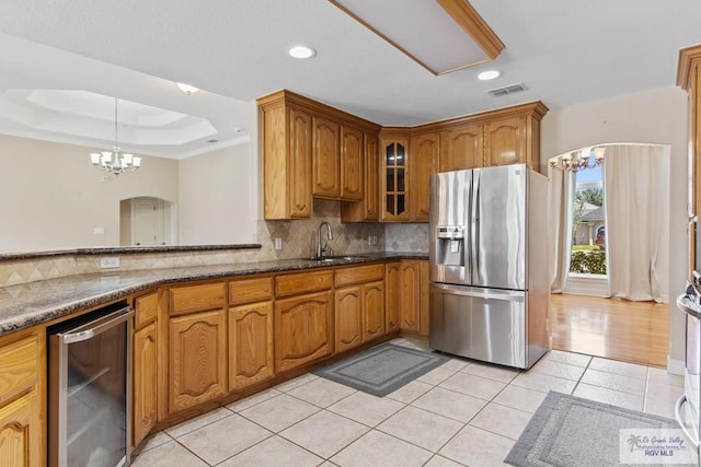 kitchen with sink, an inviting chandelier, wine cooler, stainless steel fridge with ice dispenser, and decorative backsplash