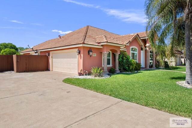 mediterranean / spanish-style home with a front lawn and a garage