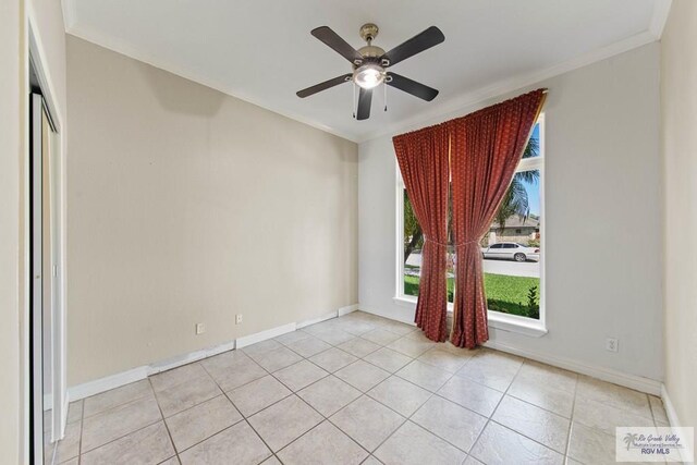 empty room featuring ceiling fan, light tile patterned floors, and ornamental molding