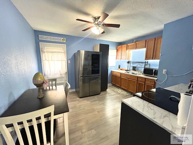 2013 E Jackson St, Harlingen, TX 78550 - kitchen featuring appliances with stainless steel finishes, a sink, ceiling fan, brown cabinetry, and light countertops