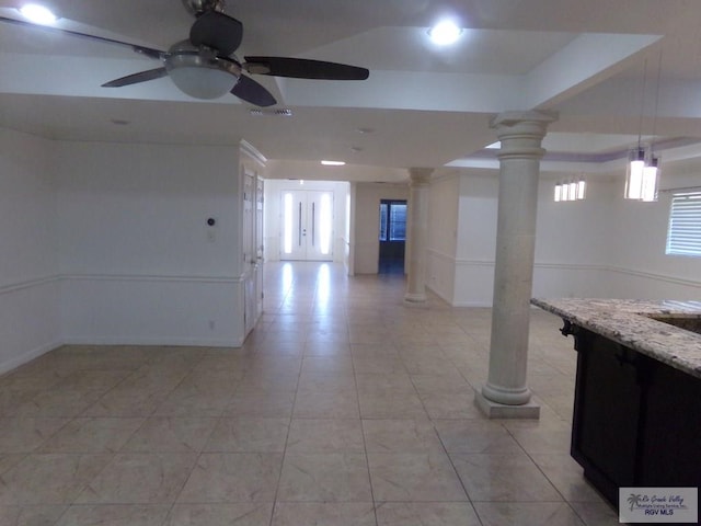 unfurnished room with ceiling fan and decorative columns