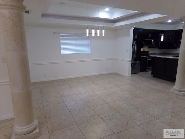 kitchen with appliances with stainless steel finishes, light tile patterned floors, a raised ceiling, and hanging light fixtures