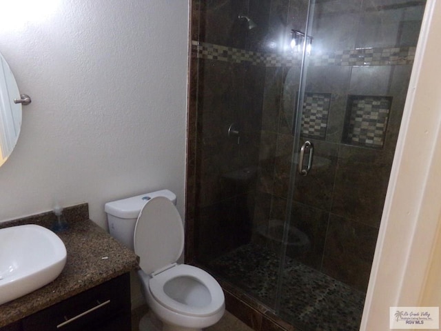 bathroom featuring vanity, toilet, and an enclosed shower