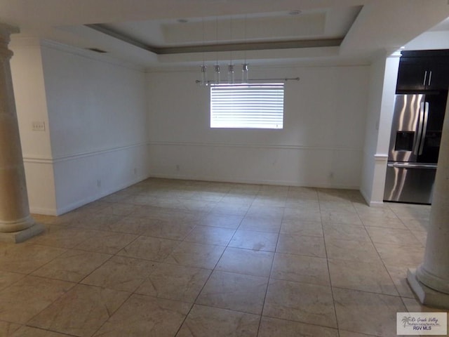 tiled empty room with a raised ceiling