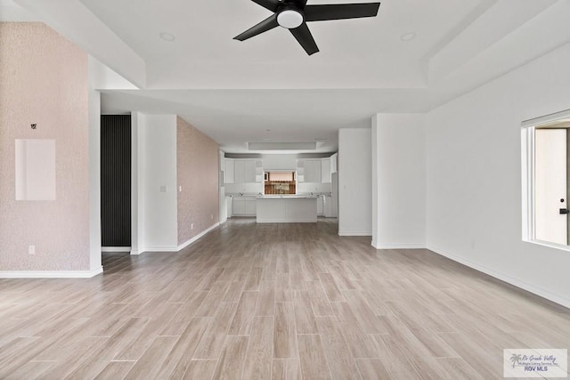 6221 King Palm Loop, Brownsville, TX 78526 - unfurnished living room featuring light wood-type flooring, a ceiling fan, and baseboards