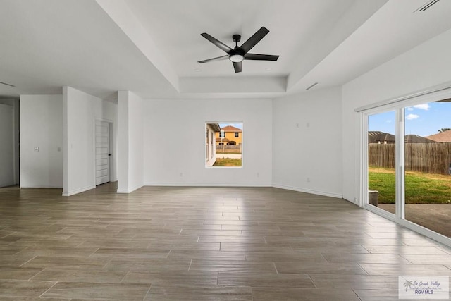 6221 King Palm Loop, Brownsville, TX 78526 - unfurnished room with a raised ceiling, healthy amount of natural light, a ceiling fan, and wood finished floors