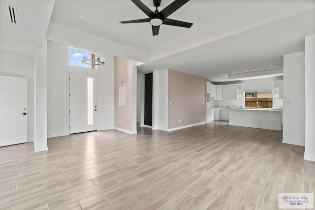 6221 King Palm Loop, Brownsville, TX 78526 - unfurnished living room with healthy amount of natural light, light wood-type flooring, and baseboards
