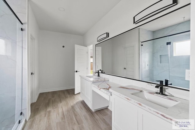 6221 King Palm Loop, Brownsville, TX 78526 - bathroom with a marble finish shower, vanity, wood finished floors, and baseboards