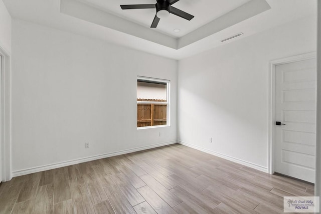 6221 King Palm Loop, Brownsville, TX 78526 - spare room with a tray ceiling, wood finished floors, ceiling fan, and baseboards