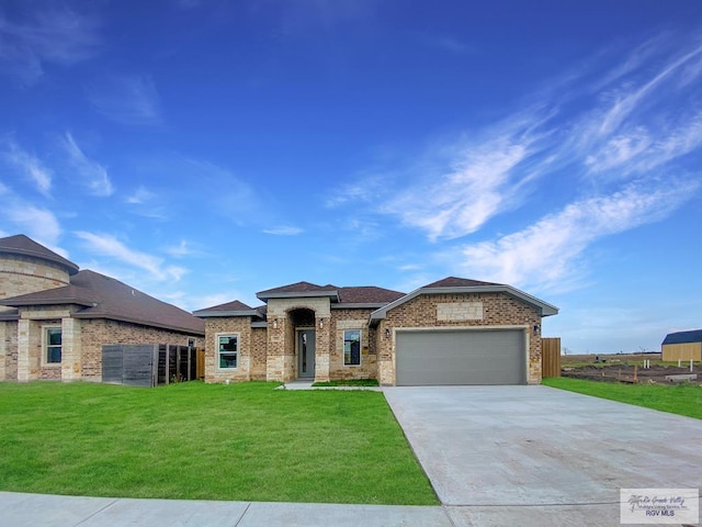 view of front of home with a front yard, brick siding, driveway, and an attached garage