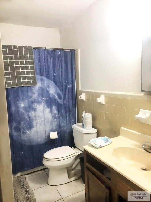 240 Palmero St, San Benito, TX 78535 - full bathroom with vanity, tile walls, tile patterned flooring, toilet, and wainscoting