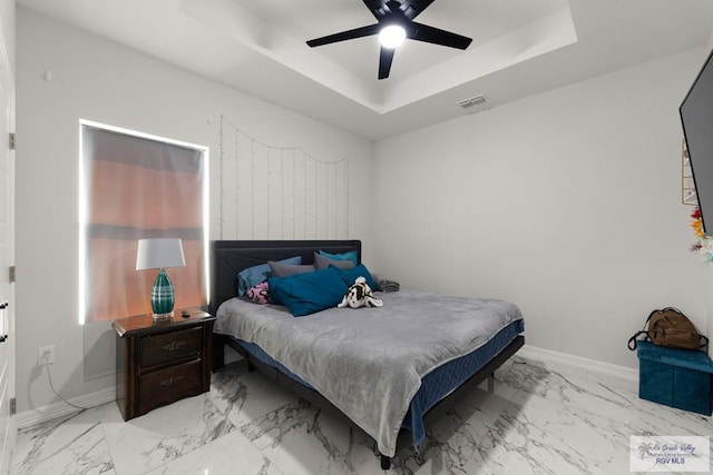 bedroom featuring a raised ceiling and ceiling fan