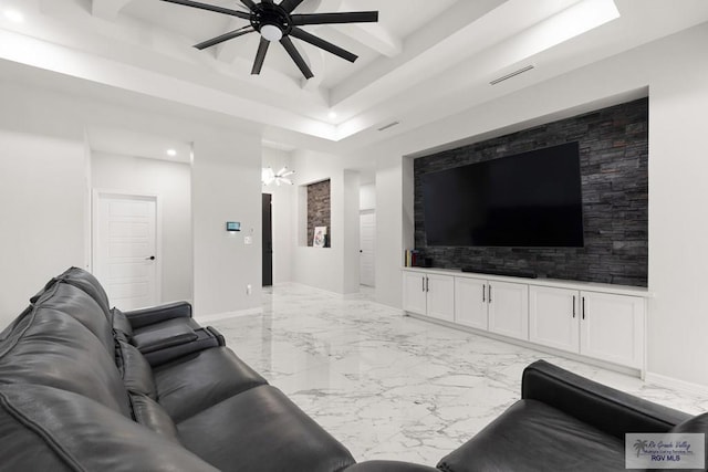 living room with ceiling fan with notable chandelier and a tray ceiling