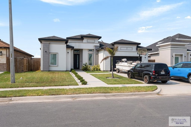 view of front of home with a garage and a front lawn